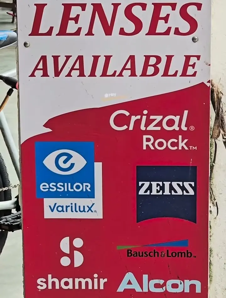 Lens brand board at Optimax Vision showing Crizal, Zeiss, Shamir, Bausch + Lomb and Alcon